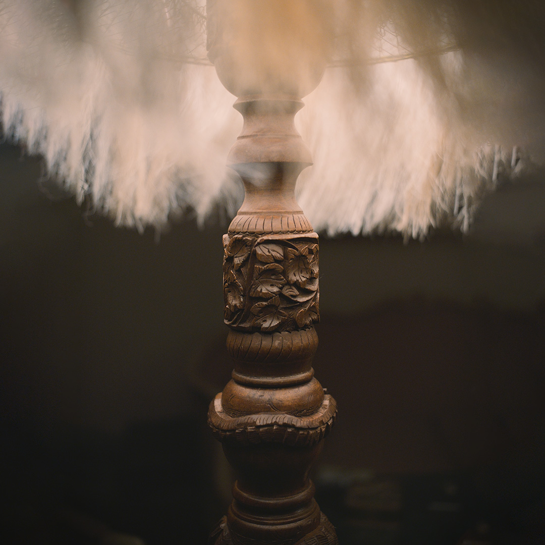 A close-up of a rustic wooden lamp with a sisal fiber shade