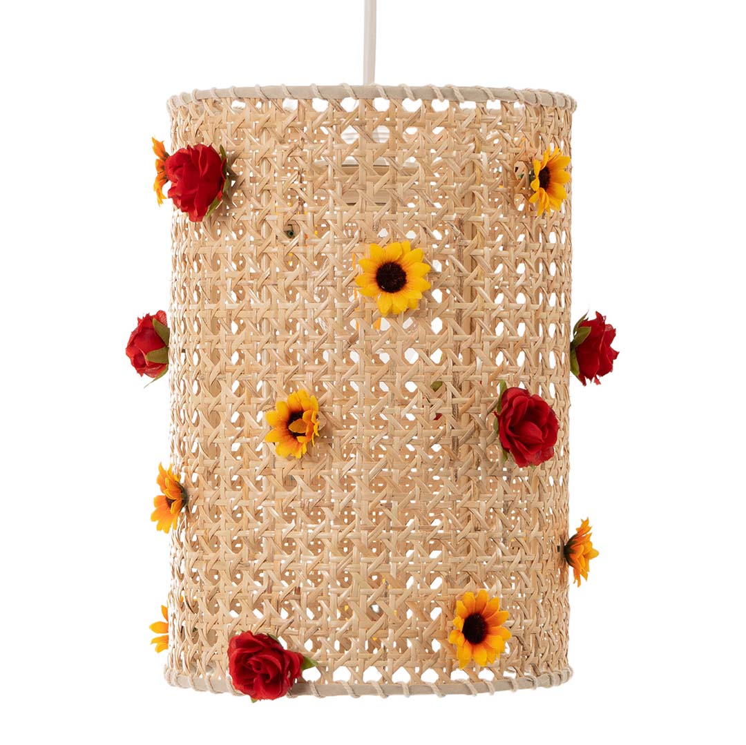 A cylindrical lampshade made of woven rattan, adorned with small red roses and yellow sunflowers.