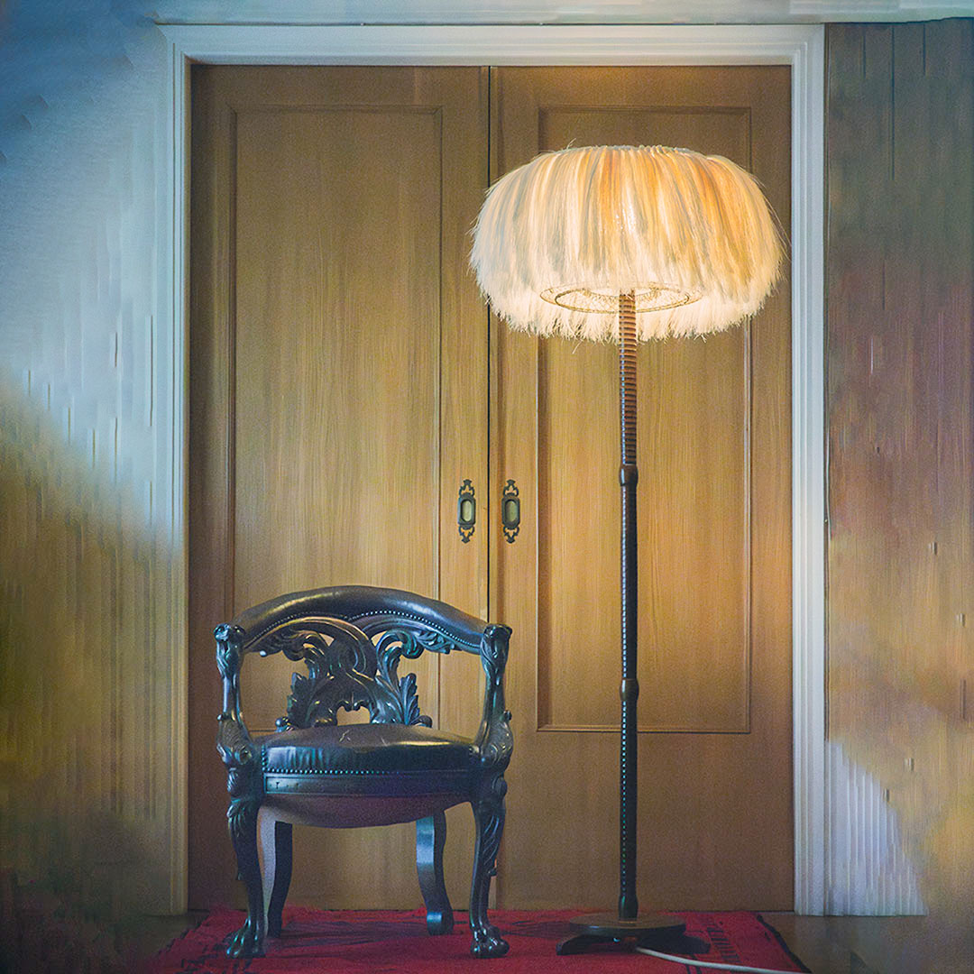 A floor lamp made with sisal fibers sitting next to a wooden chair