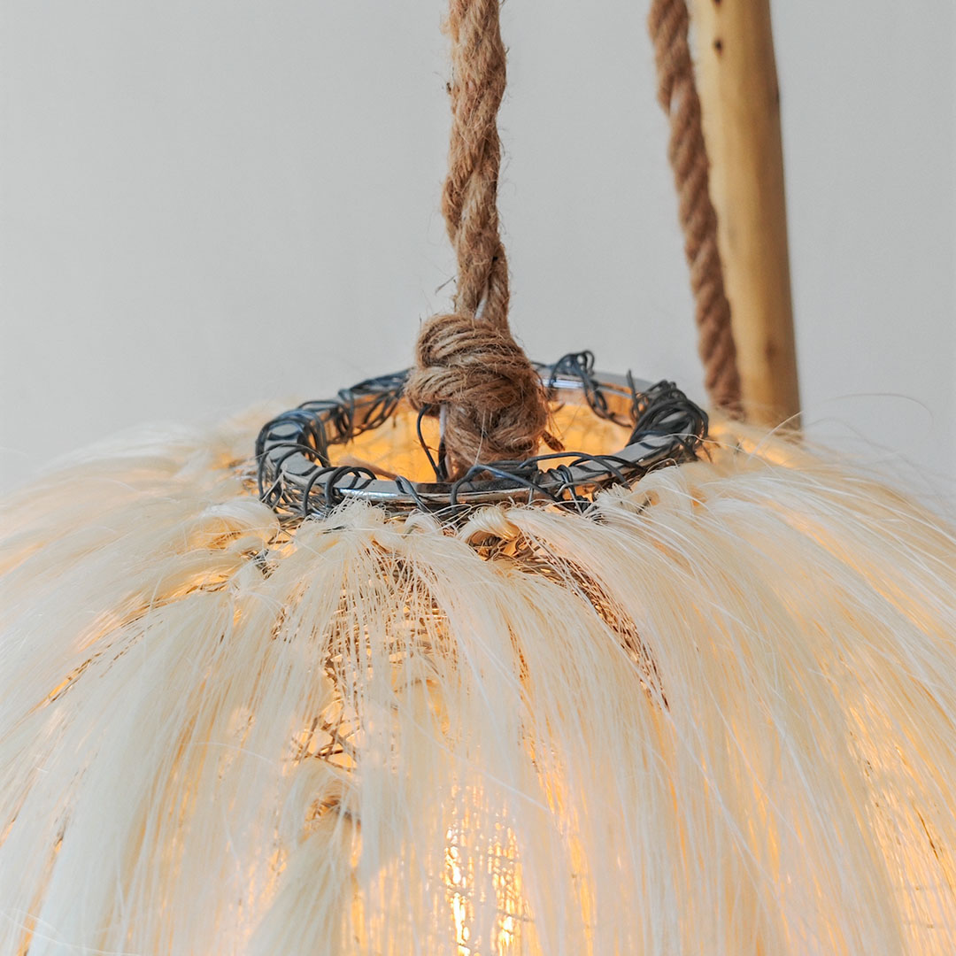 A close-up photo of a sisal lamp hanging from a rope. 