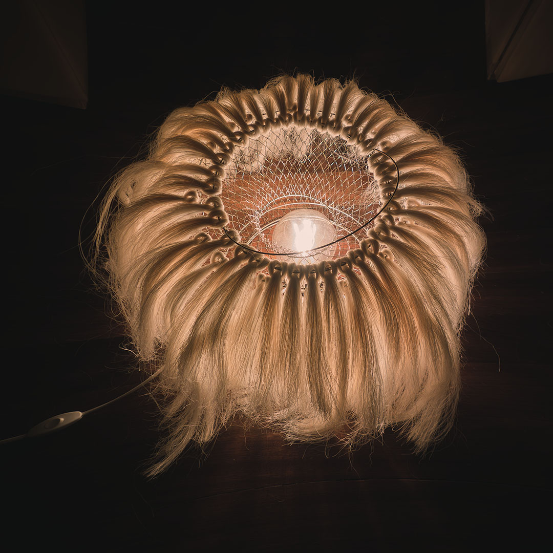 A lamp made out of a wire fish basket and sisal fibers