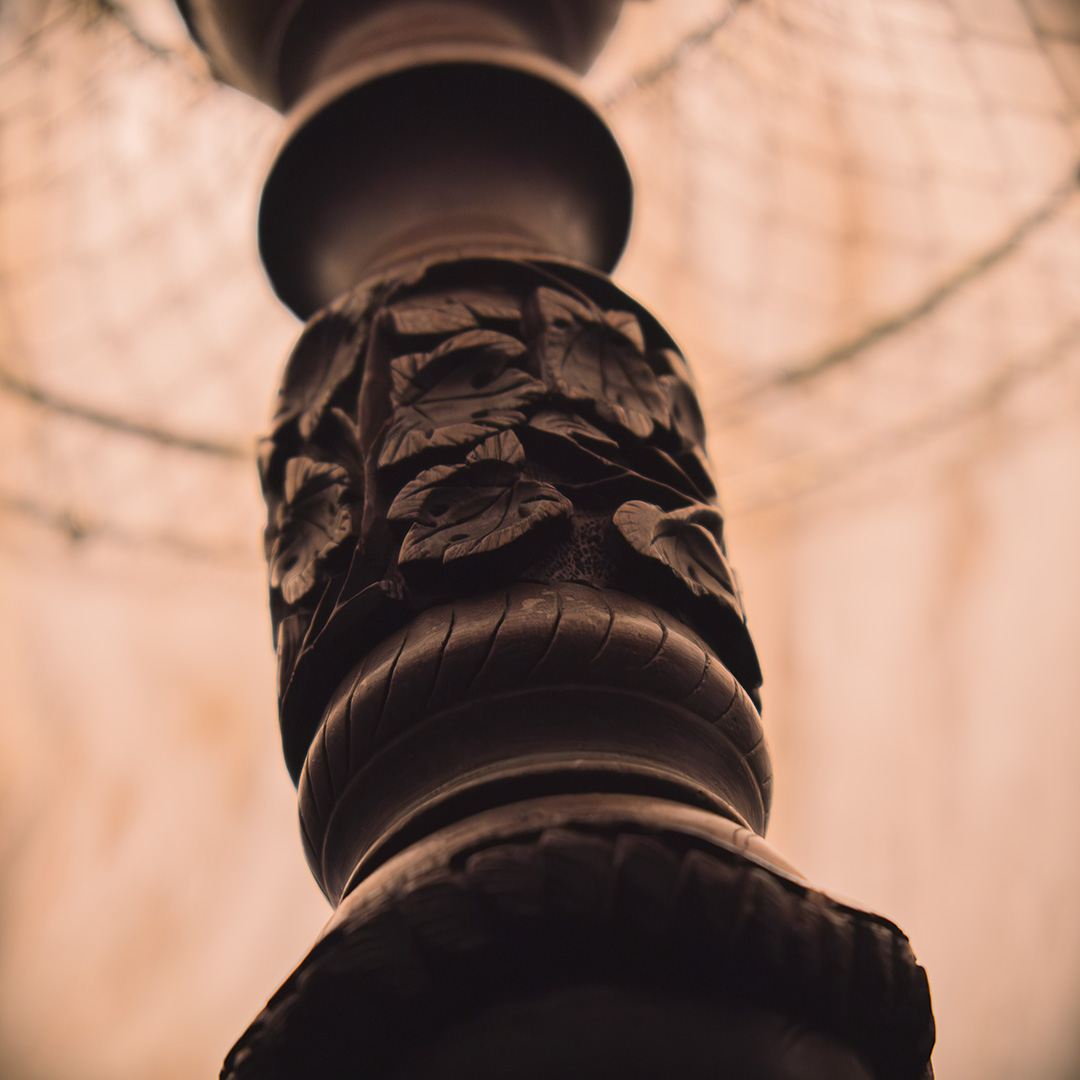 A close-up of a carved wooden lamp base